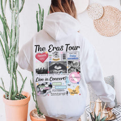 a woman wearing a white hoodie with the words the eras tour printed on it
