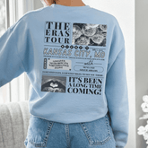 a woman wearing a blue sweatshirt with pictures on it