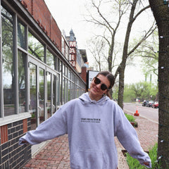 a woman standing in front of a brick building