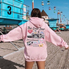 a woman in a pink hoodie on the beach