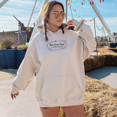 a woman in a white hoodie is standing in front of a ferris wheel
