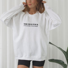 a woman wearing a white sweatshirt and black shorts