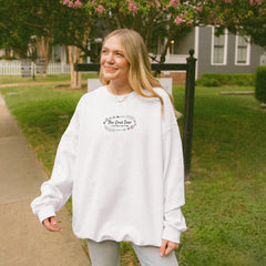 a woman standing on a sidewalk in front of a house