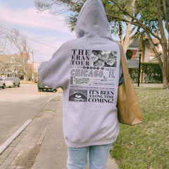 a person in a hoodie walking down a sidewalk