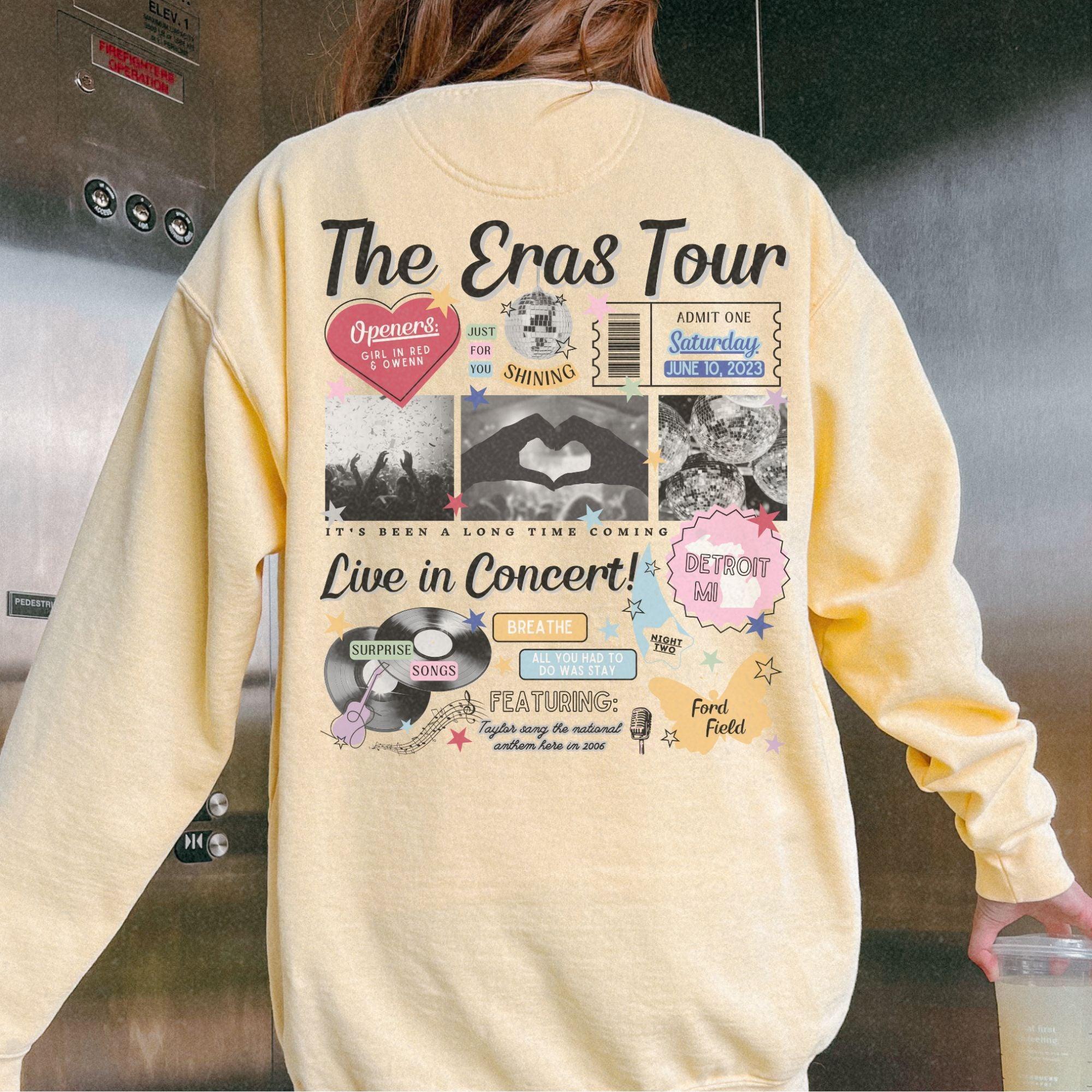 a woman wearing a yellow sweatshirt with the words the eras tour on it