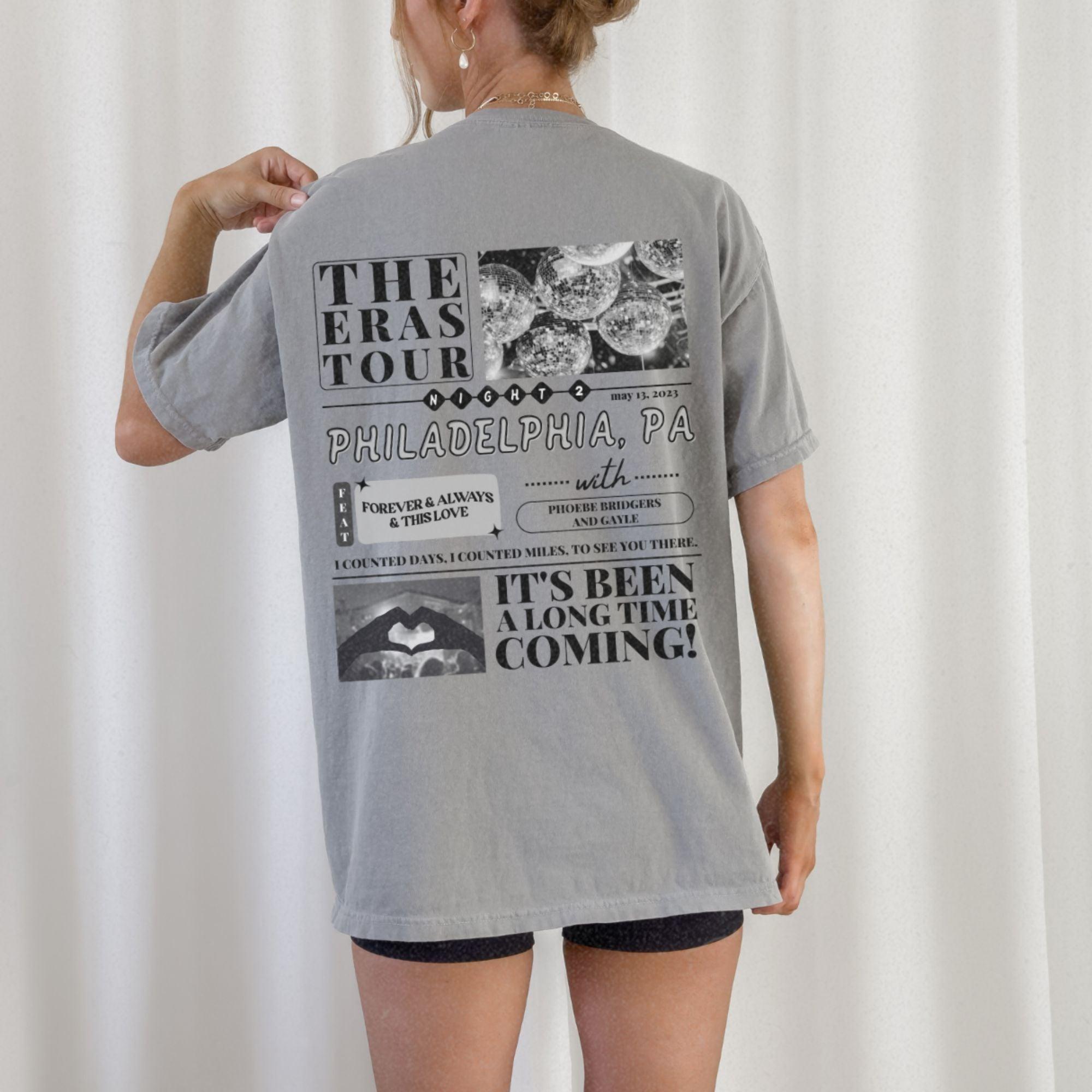 a woman wearing a gray shirt with pictures on it