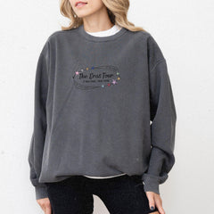 a woman wearing a grey sweatshirt with the words the exo tour on it