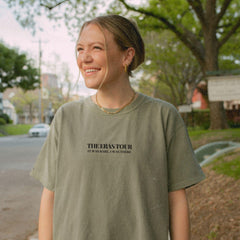 a woman standing on the side of a road smiling