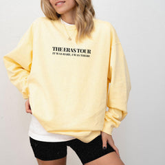 a woman wearing a yellow sweatshirt and black shorts