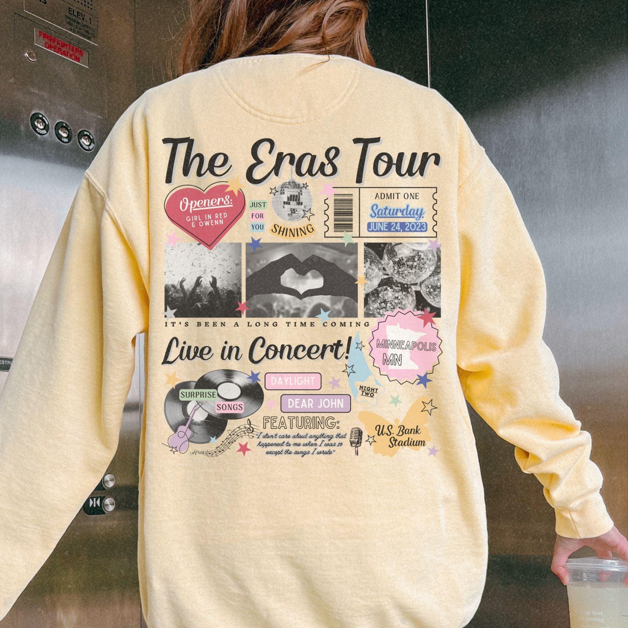 a woman wearing a yellow sweatshirt with the words the eras tour on it