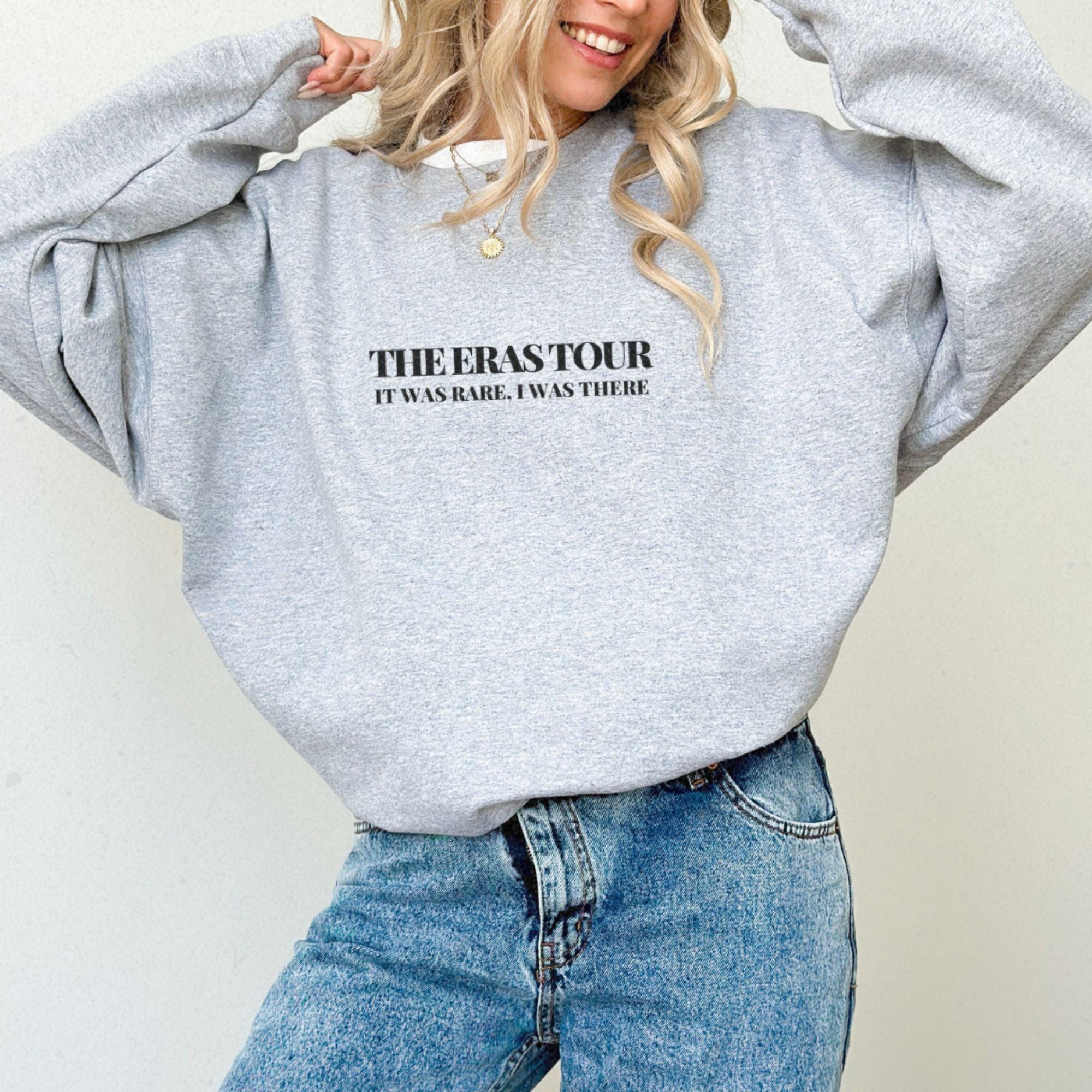 a woman wearing a grey sweatshirt with the words the seastour on it