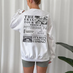 a woman wearing a white sweatshirt and shorts