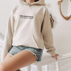 a woman wearing a hoodie and ripped shorts
