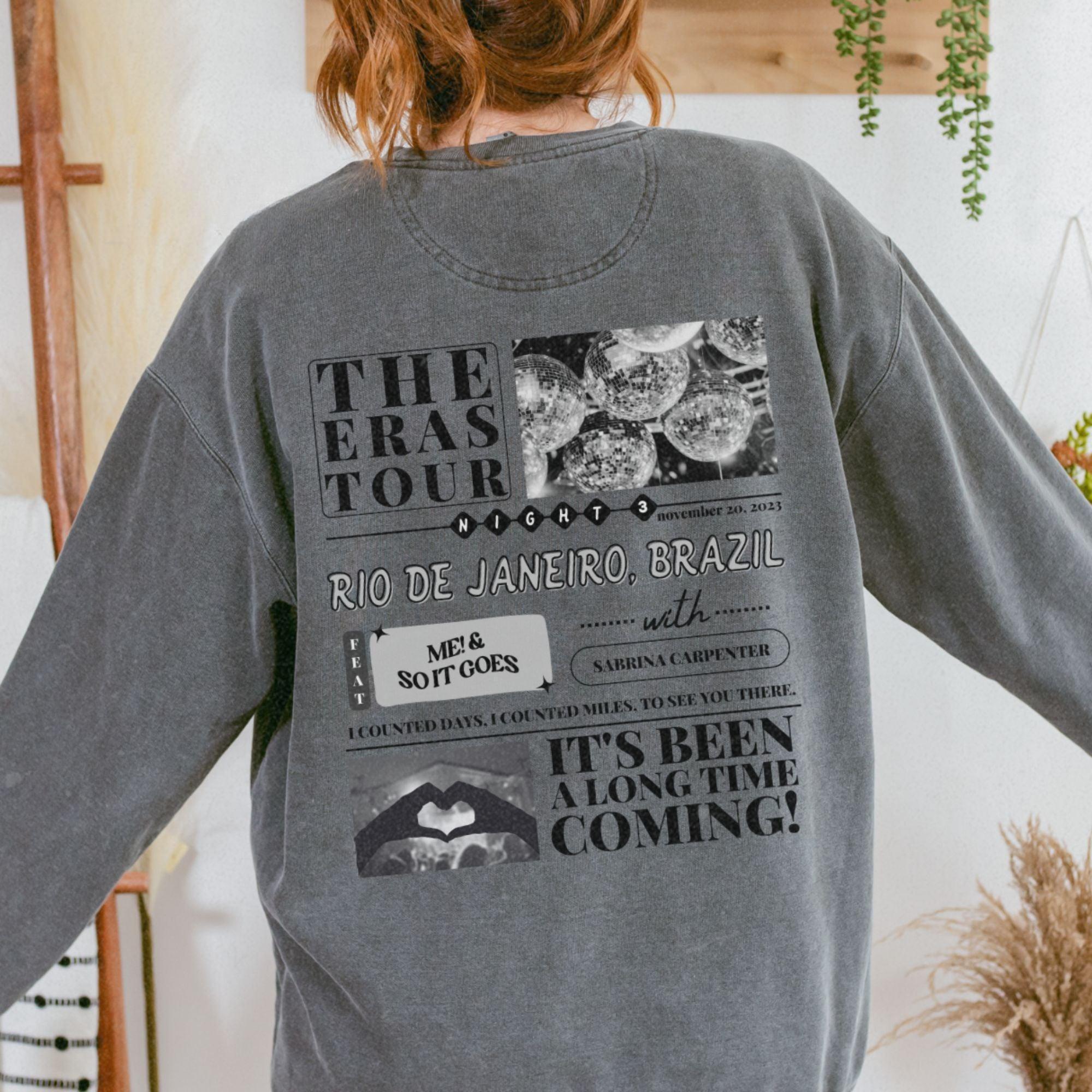 a woman wearing a gray sweatshirt with pictures on it