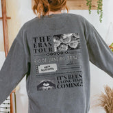 a woman wearing a gray sweatshirt with pictures on it