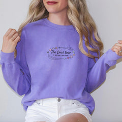 a woman wearing a purple sweatshirt and white shorts