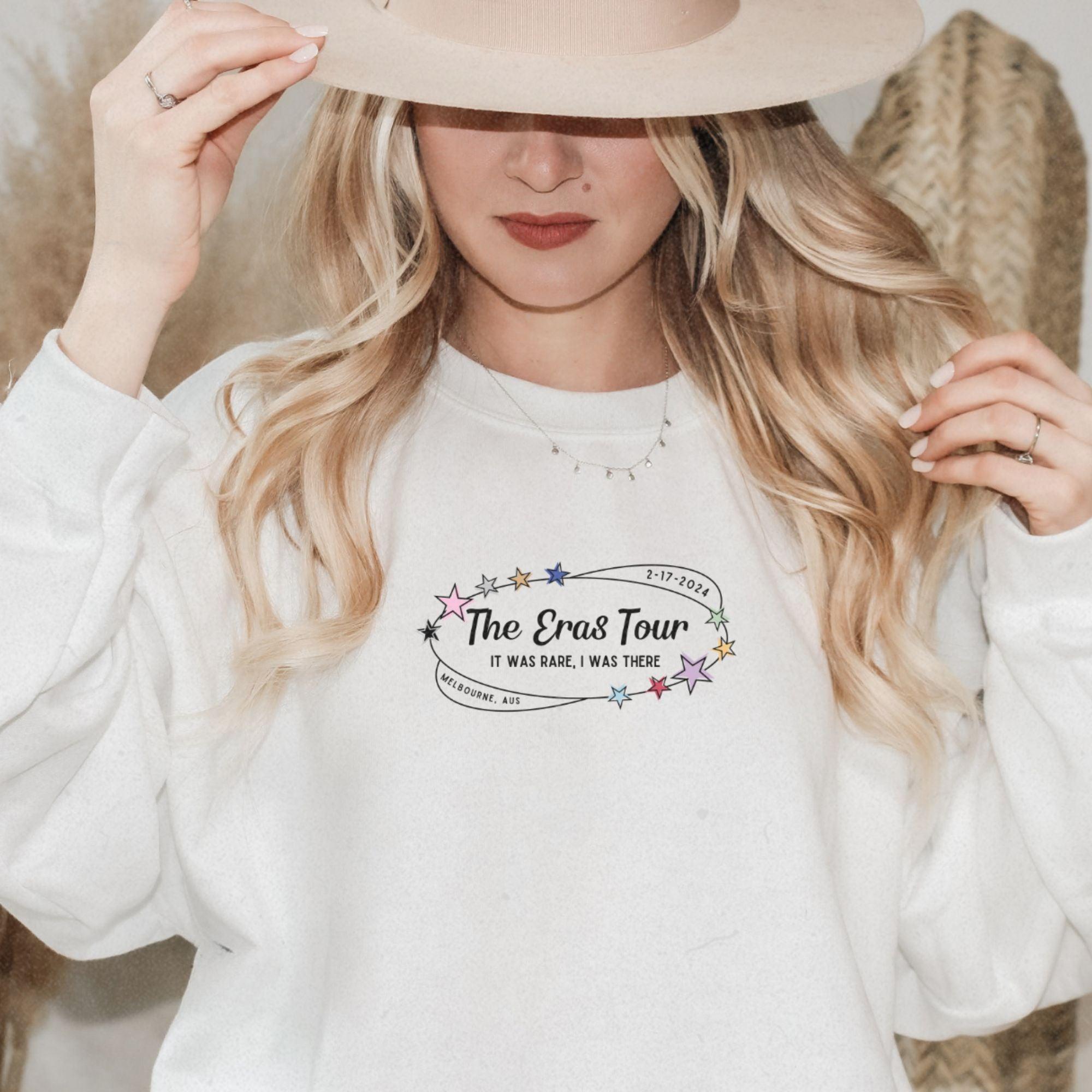 a woman wearing a white sweatshirt and a hat