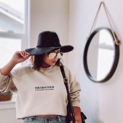 a woman wearing a black hat and a white sweatshirt