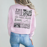 a woman wearing a pink sweatshirt and jeans