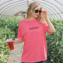 a woman in a pink shirt holding a drink