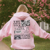 a girl in a pink hoodie is holding a frisbee