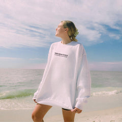 a woman standing on a beach next to the ocean