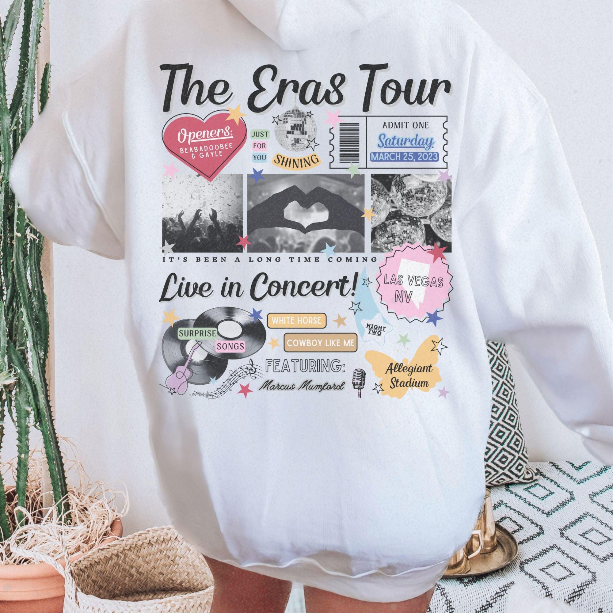 a person wearing a white hoodie with the words the eras tour on it