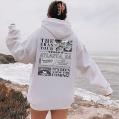 a person standing on a beach with a hoodie on