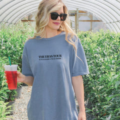 a woman holding a drink in a greenhouse