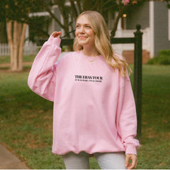 a woman wearing a pink sweatshirt and jeans