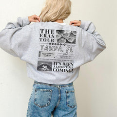 a woman wearing a sweatshirt with a picture of the eras tour on it