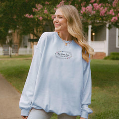 a woman standing on a sidewalk in front of a house