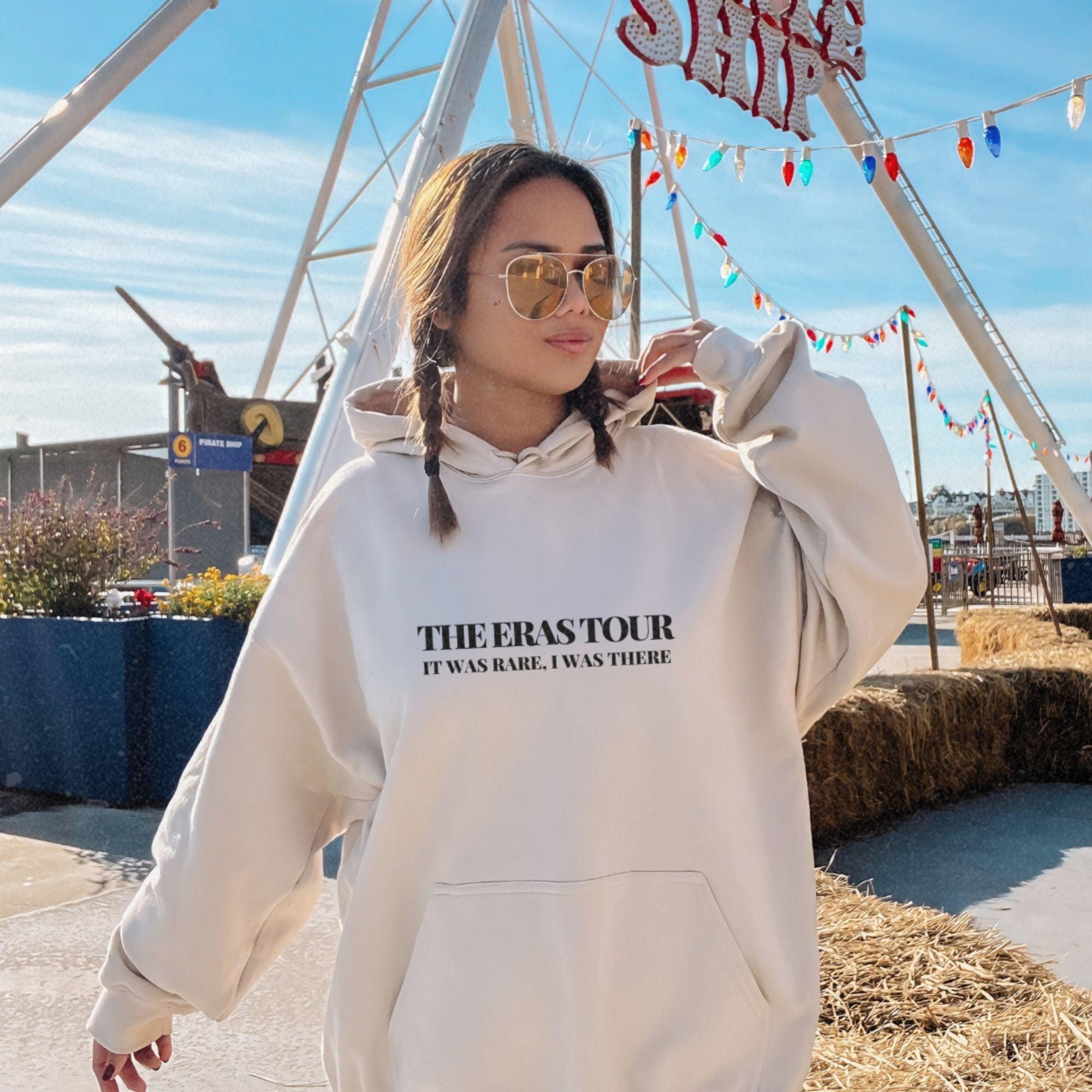 a woman wearing a white sweatshirt and sunglasses