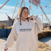 a woman wearing a white sweatshirt and sunglasses