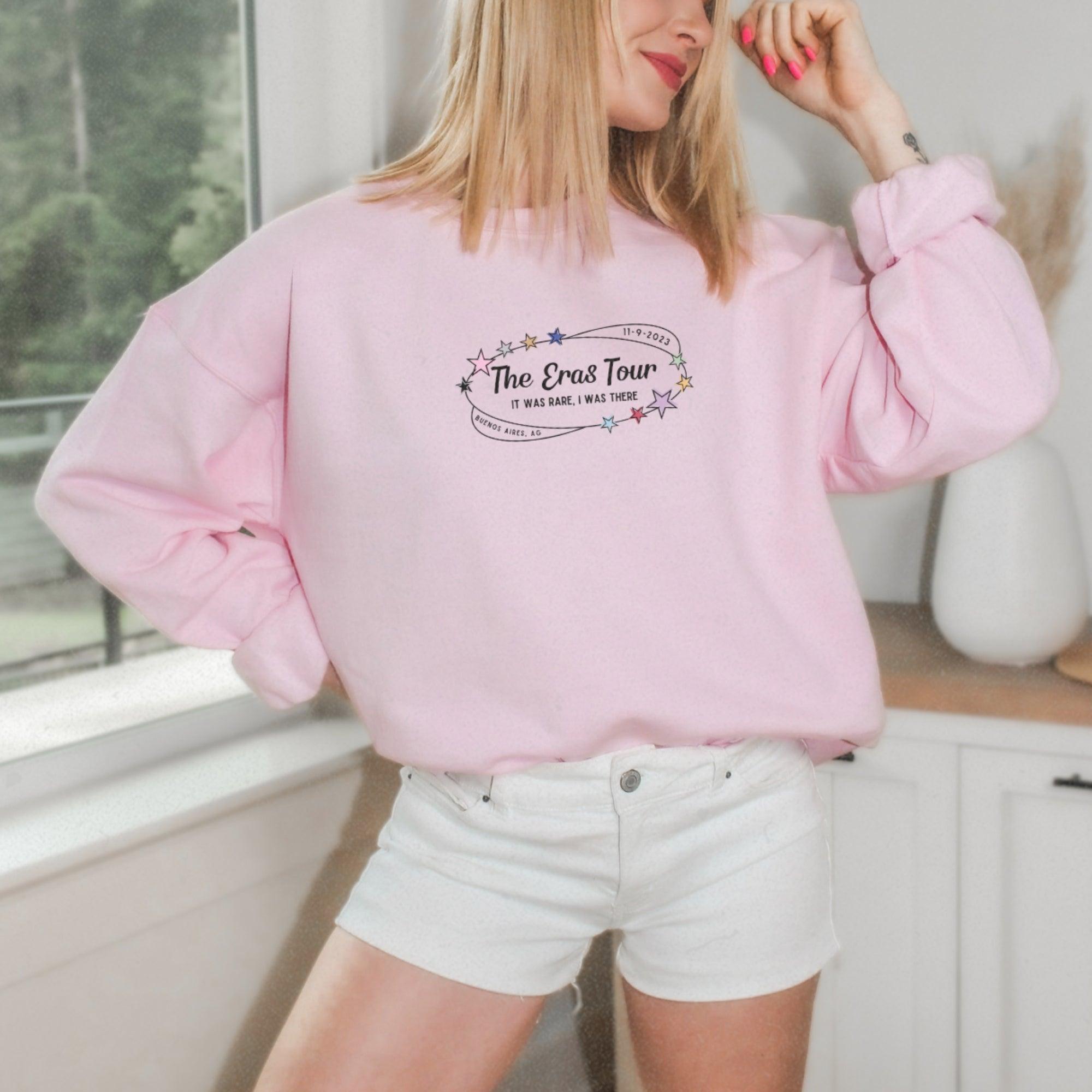 a woman wearing a pink sweatshirt and white shorts