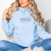 a woman sitting on a couch wearing a blue hoodie