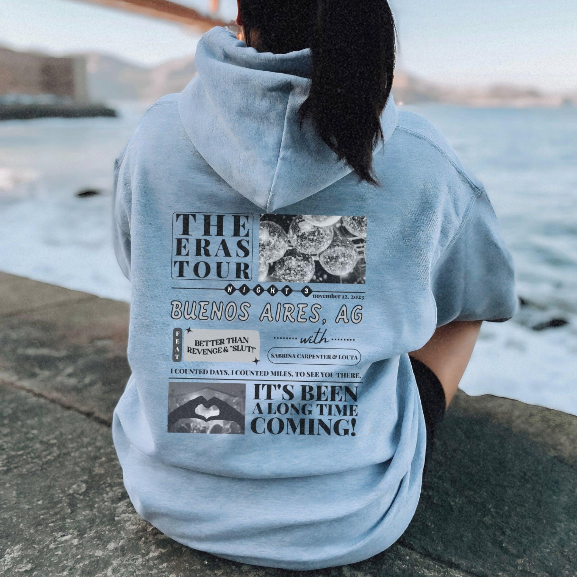 a woman sitting on a rock looking at the water