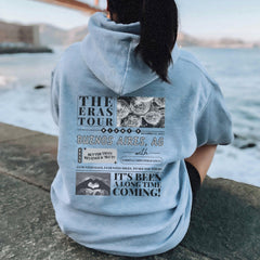 a woman sitting on a rock looking at the water