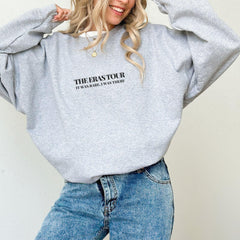 a woman wearing a grey sweatshirt and jeans