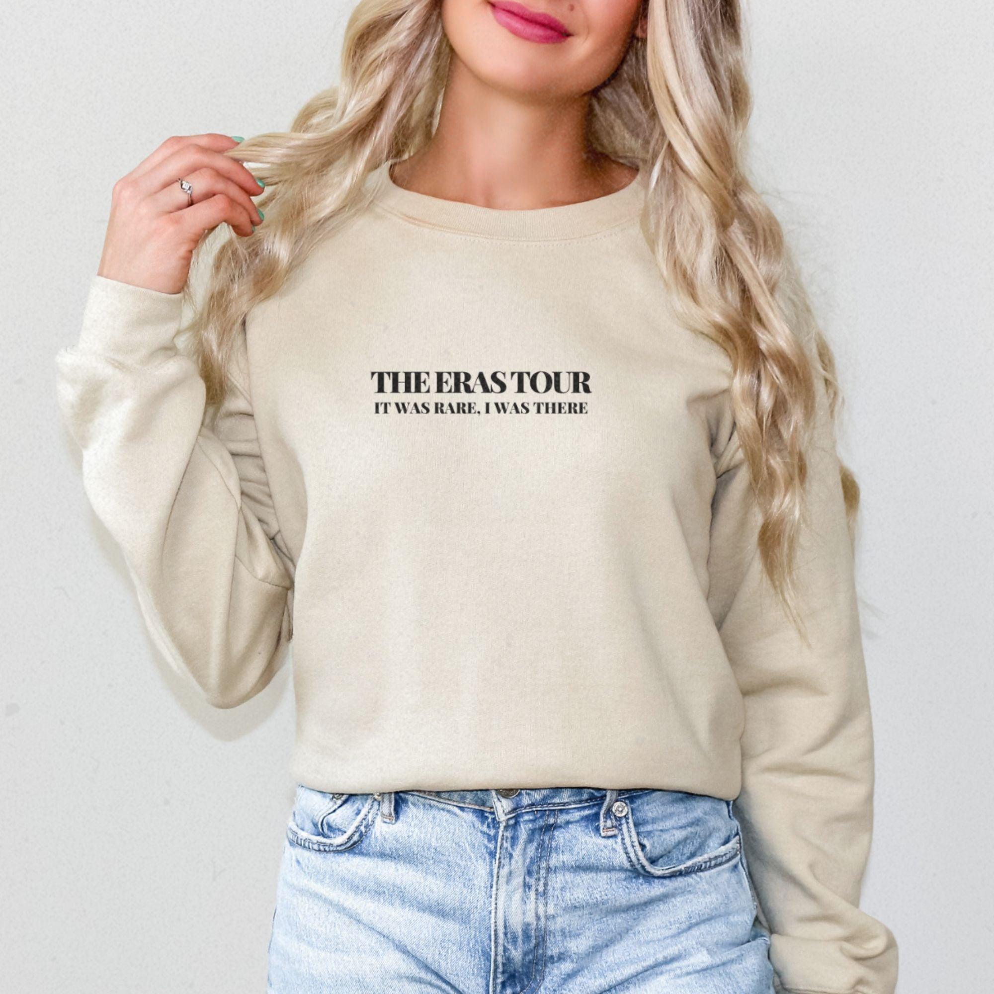 a woman with blonde hair wearing a sweatshirt and jeans