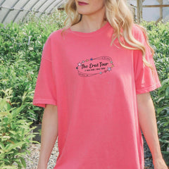 a woman in a pink shirt is standing in a greenhouse