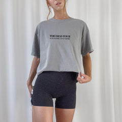 a woman wearing a grey shirt and black shorts