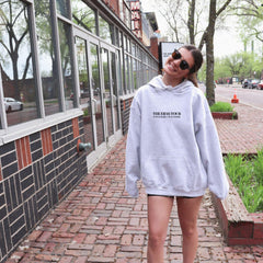 a woman walking down a brick sidewalk in front of a building