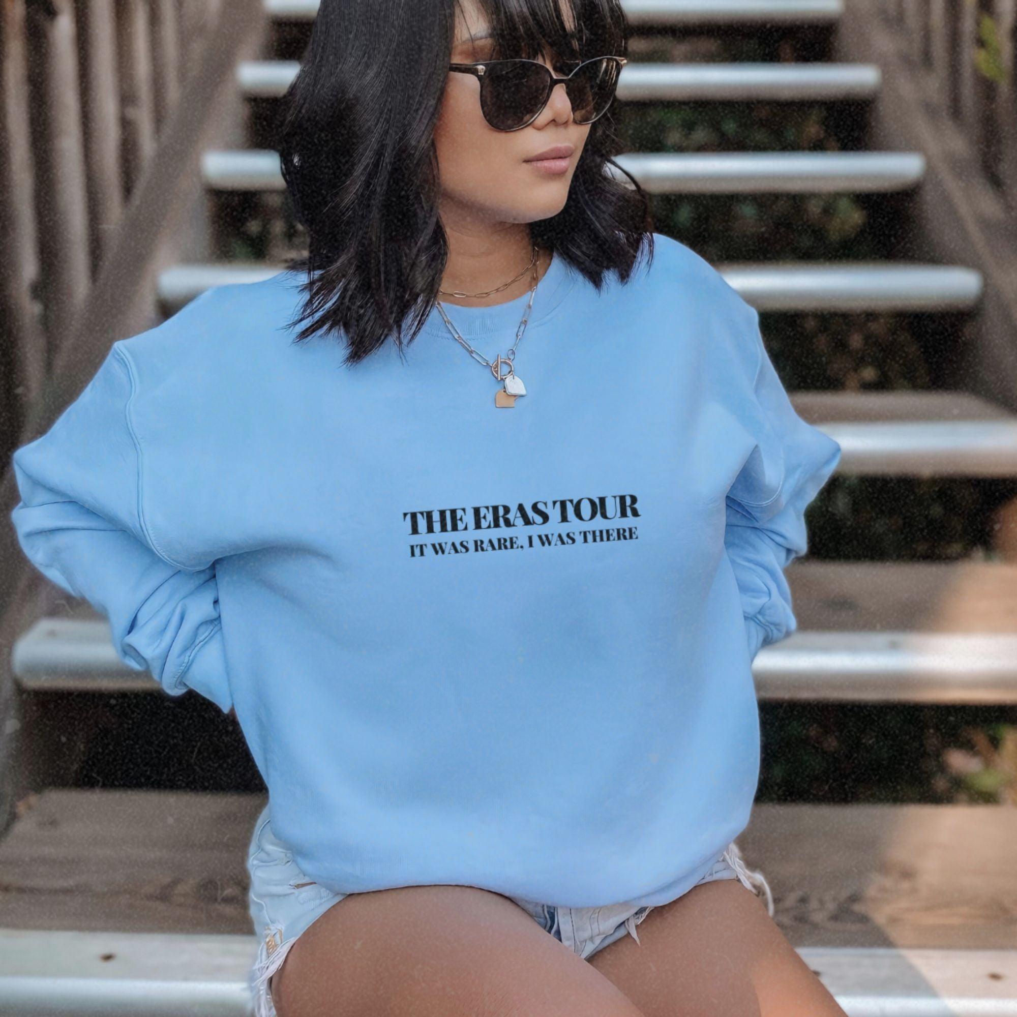 a woman in a blue sweatshirt sitting on some steps