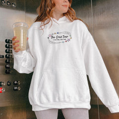 a woman in a white hoodie holding a drink