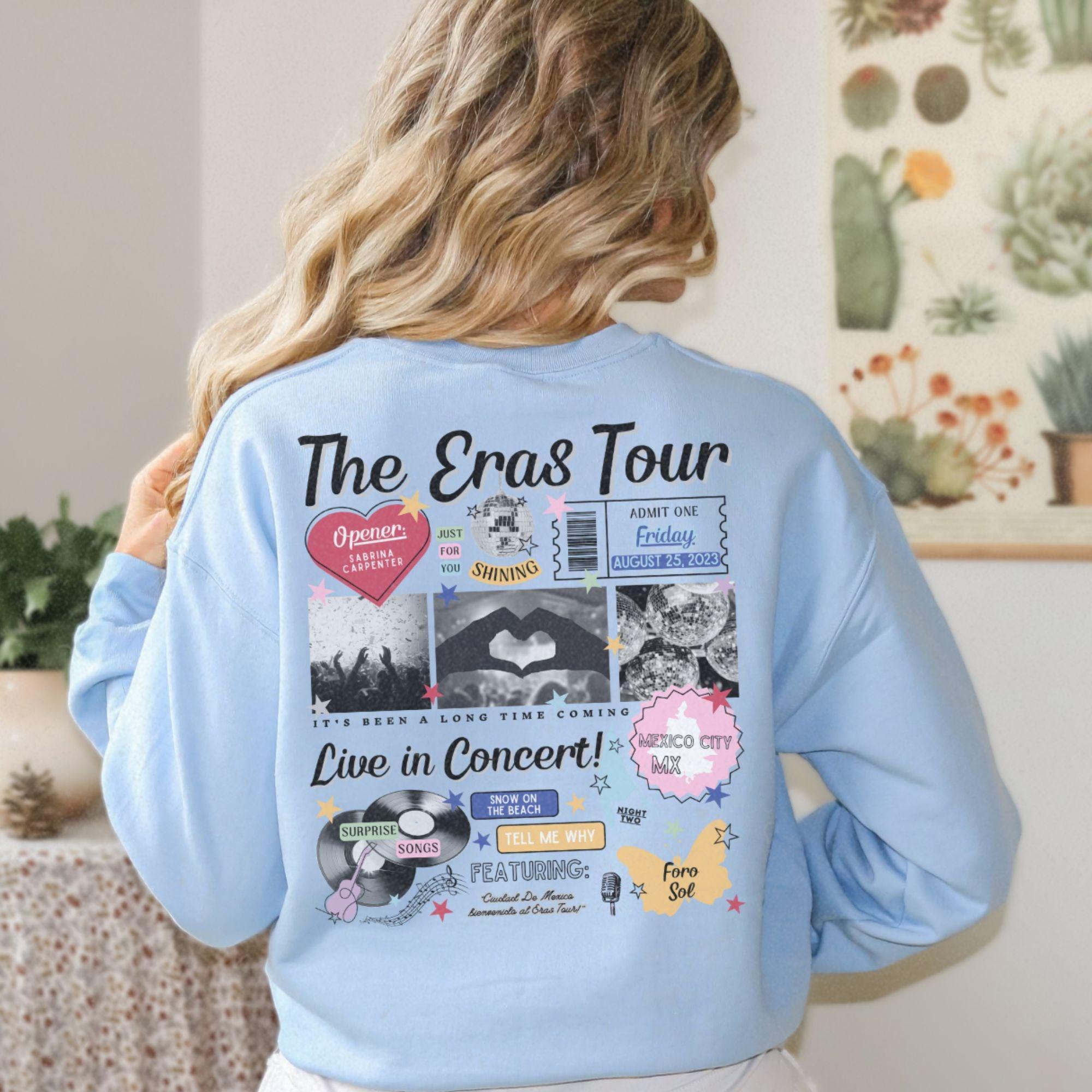 a woman wearing a blue sweatshirt with the words the eras tour on it