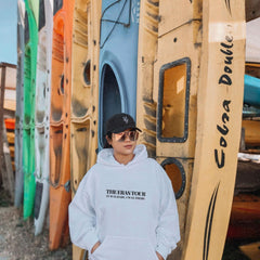 a man standing in front of a row of surfboards