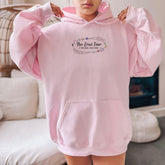 a woman in a pink hoodie is holding up her pink hoodie