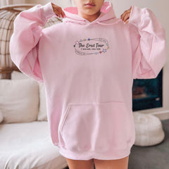 a woman in a pink hoodie is holding up her pink hoodie