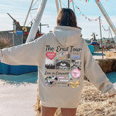 a woman in a white hoodie standing in front of a ferris wheel